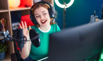 A woman streamer playing video games at a desktop computer.
