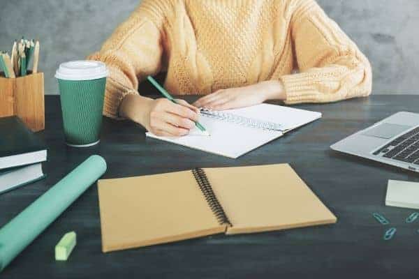 Woman writing at desk in home office