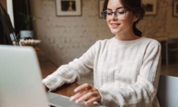 A woman working remotely at her home office desk, using a laptop.