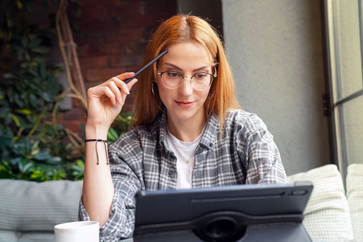 A woman searching for jobs on a laptop for blog post organize your job search
