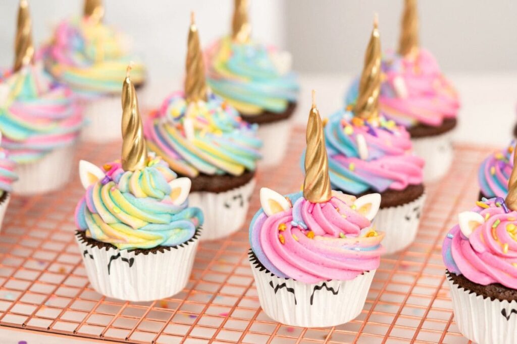 A tray of homemade unicorn-themed decorated cupcakes.