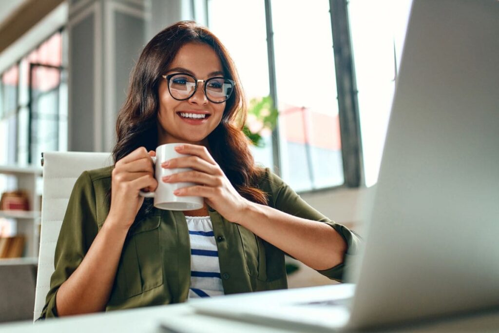 A woman working from home on a laptop, creating a membership website.