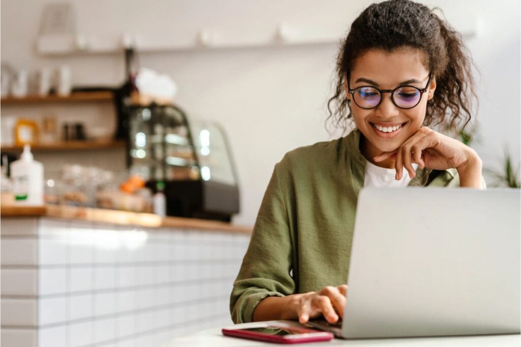 A women working remotely on a laptop in a cafe.