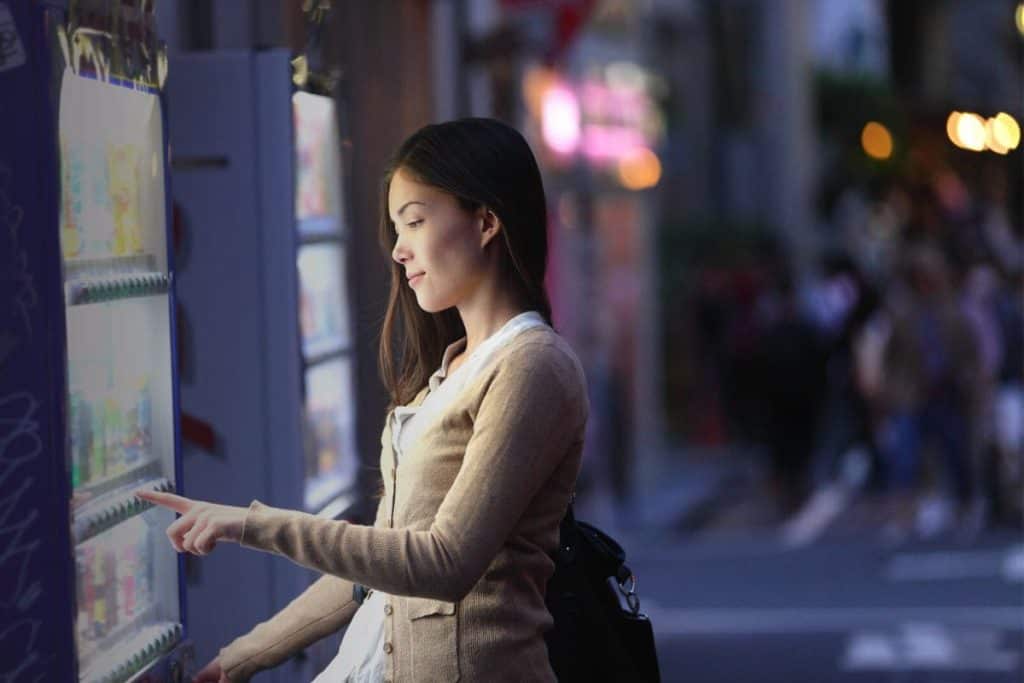 Woman using a vending machine.
How to Start a Vending Machine Business