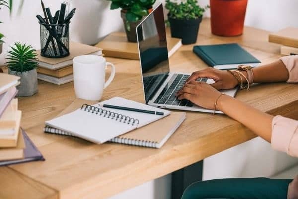 Woman writing resignation letter on laptop.