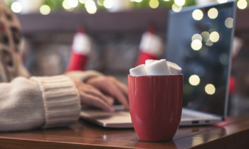 Lonely woman freelancer enjoying with cup of hot chocolate working to make Christmas cash