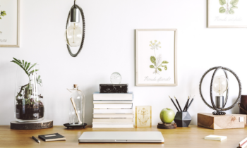 Modern home office interior with wooden desk, books, laptop, and more
