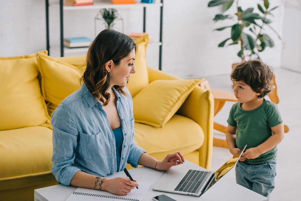 mom working on short tasks while son plays in the background