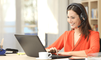 Young brunette woman working in her home office taking customer service calls