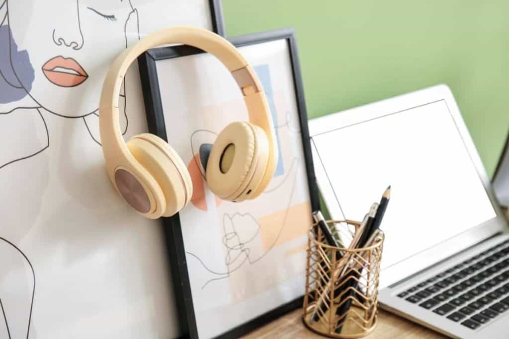 A transcriptionists' home office, with laptop, headphones, and framed pictures.