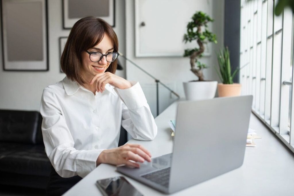A freelancer working from home, sitting at a desk, using a laptop.