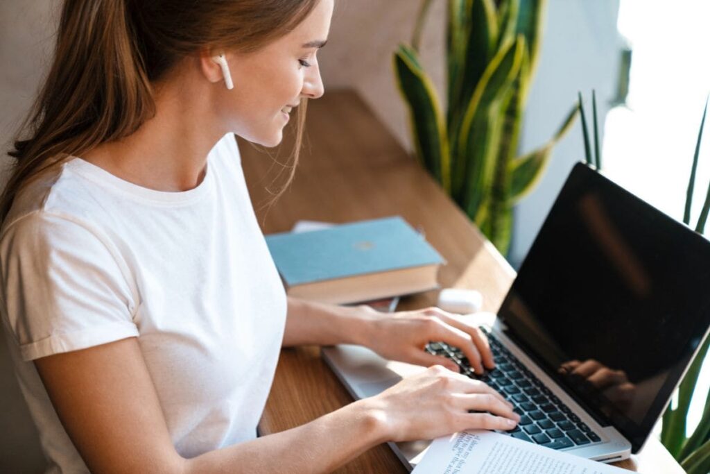 A college student is working on a laptop at his desk at home.