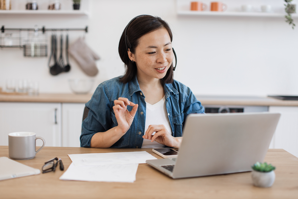 woman sitting at her desk in a meeting - blog post work at home jobs with Google