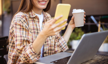 Woman using her smartphone to earn free starbucks gift cards while drinking coffee