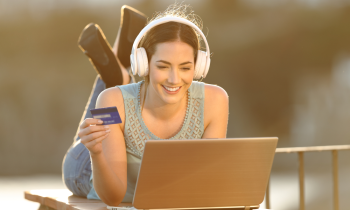 Woman wearing headphones earning gift cards on her laptop