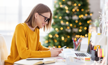 Woman working from home in front of Christmas tree