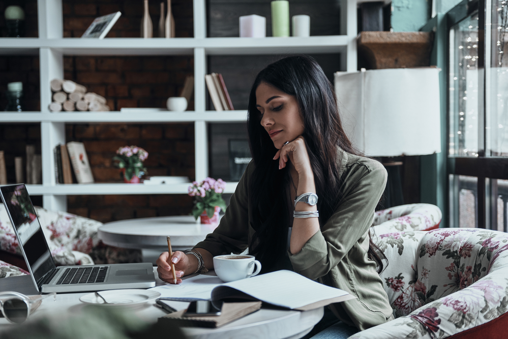 Woman writing in a notebook for the blog post finding your career path