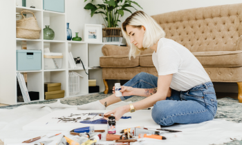 Young artist sitting on the floor painting a tapestry