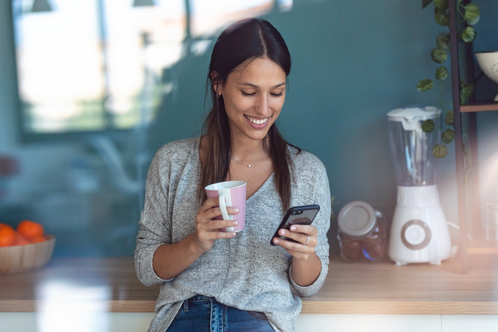 Young woman using smartphone to make money with inboxdollars