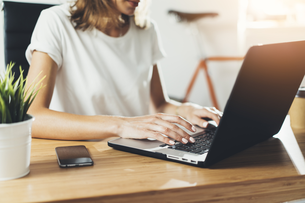 Young woman working at home on her laptop doing her data entry jobs