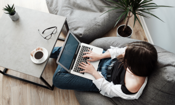 young woman working in her NY city apartment on her laptop