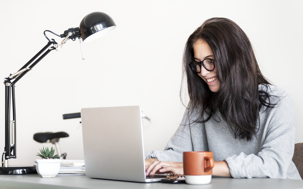 Woman working at home typing on laptop